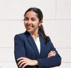 Confident ambitious young professional smiling an camera. Portrait of young woman with arms crossed wearing formal suit and posing on outdoor stairs. Young businesswoman concept